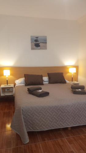 a bedroom with a large bed with two lamps at Lido in Mar del Plata