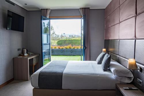 a bedroom with a large bed and a large window at Alda Carballo in Carballo