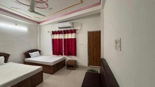 a small room with a bed and a red curtain at Subhash Guest House in Gaya