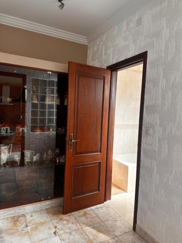 a bathroom with a wooden door and a shower at Azor International House in Ponta Delgada