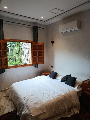 a bedroom with a large bed and a window at villa ourika complette in Sbiti