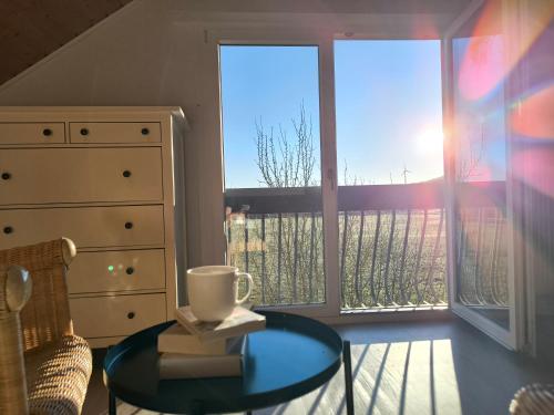 a living room with a glass table and a window at Ferienwohnung am Soonwald in Ellern