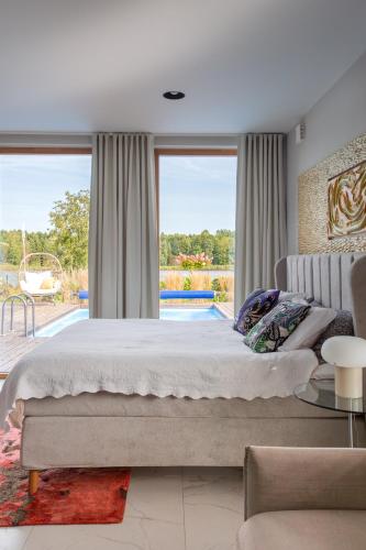 a bedroom with a large bed and a large window at Villa Sirena Apartments in Pärnu