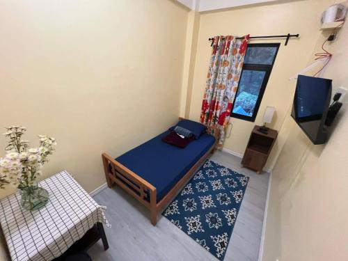 a small room with a bed and a tv at Tipid Camp Baguio A4,A5,A6 in Baguio