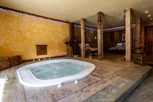 a jacuzzi tub in a room with a bedroom at La Luge D'Antan Maison d'Hôtes & SPA in Brusson