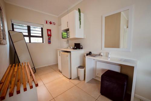 a kitchen with a counter and a table and a sink at Interlaken Guest House in Wilderness