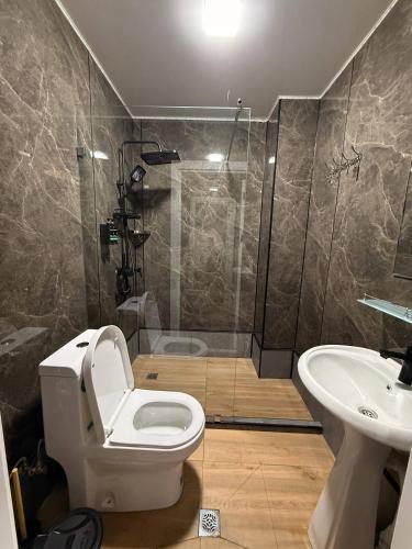 a bathroom with a shower and a toilet and a sink at TWENTY Hostel in Samarkand