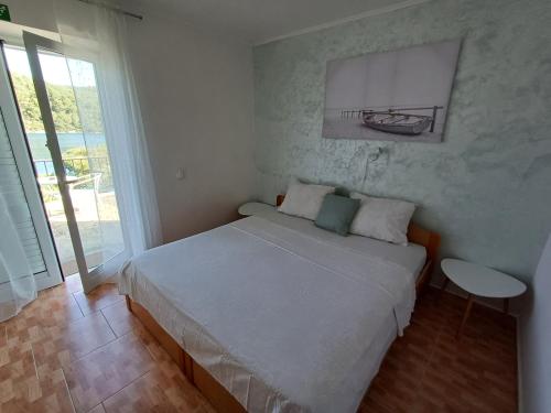 a small bedroom with a bed and a window at Guest House Radulj in Polače