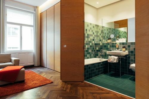a bathroom with a shower and a sink and a tub at Buxbaum Beletage Design & Boutique Hotel in Vienna