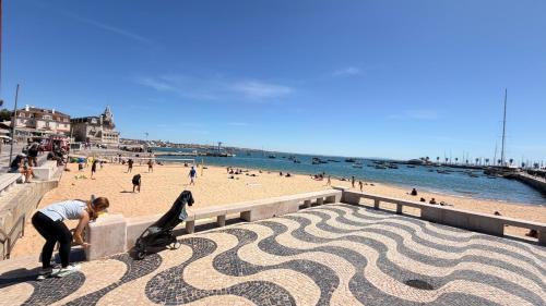 a person riding a skateboard on a wall next to a beach at Spacious studio apartment in the heart of Cascais historic center in Cascais