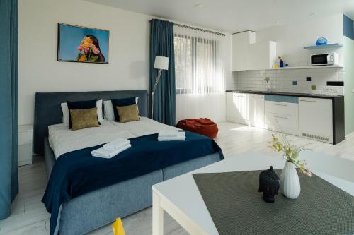 a bedroom with a blue and white bed and a table at Žvėrinčiaus vila in Birštonas