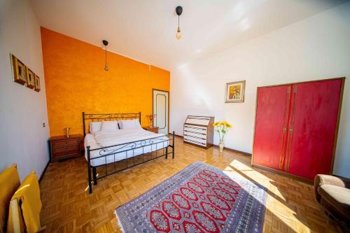 a bedroom with a bed and a red door at Casa Burnie in Monte Molino