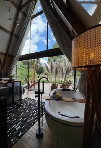 a large bathroom with a tub and a large window at Hospedagem de Charme Te Amo in Canela