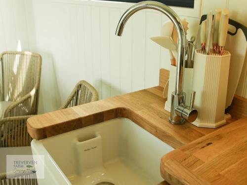 a kitchen sink with a wooden counter top at St Loy & Penberth Shepherds' Huts in Saint Buryan