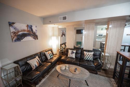 a living room with leather couches and a table at Stay Together Suites - Penthouse On The Strip Sleeps 20 - NO RESORT FEE in Las Vegas
