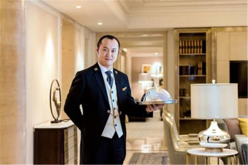 a man in a suit and tie holding a silver tray at Sofitel Shanghai Hongqiao in Shanghai