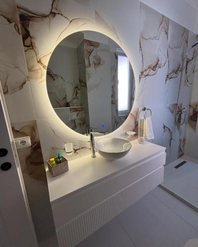 a bathroom with a sink and a mirror at E&O Apartment in Pogradec