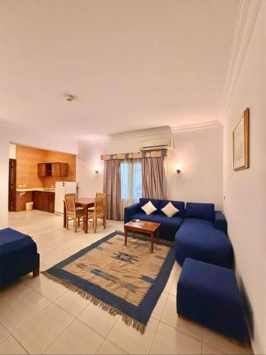 a living room with a blue couch and a table at 4S Hotel Dahab in Dahab