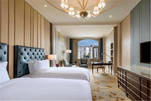 a bedroom with two beds and a living room at Sofitel Shanghai Hongqiao in Shanghai