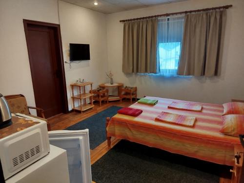a bedroom with a large bed and a table at Proboyski Guest House in Tryavna