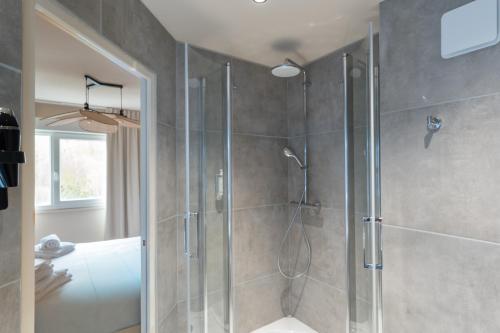 a bathroom with a shower with a glass door at BHOMA Bourges - Hôtel in Bourges