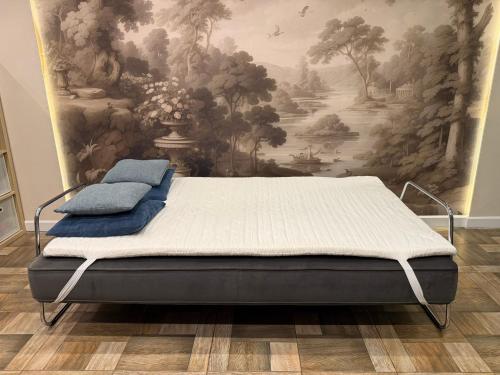 a bed in a room with a painting on the wall at Borki Guest House in Smardzewice