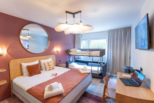 a bedroom with a bed and a desk and a mirror at BHOMA Bourges - Hôtel in Bourges