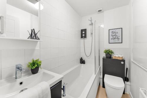 a white bathroom with a toilet and a sink at The Derby Escape - Garden -Sleeps 6 in Derby