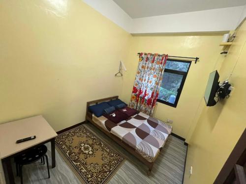 a small bedroom with a bed and a window at Tipid Camp Baguio A2,A3,A7,A8 in Baguio