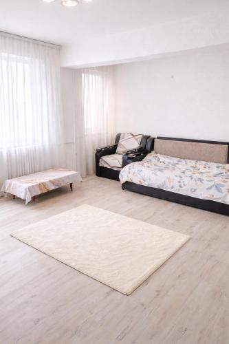 a living room with two beds and a rug at Ploiești Centru in Ploieşti