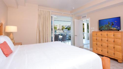 a bedroom with a large white bed and a television at 115 Mariners Club in Key Largo