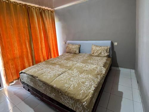 a bed in a room with an orange curtain at Diva sunset garden in Senaru
