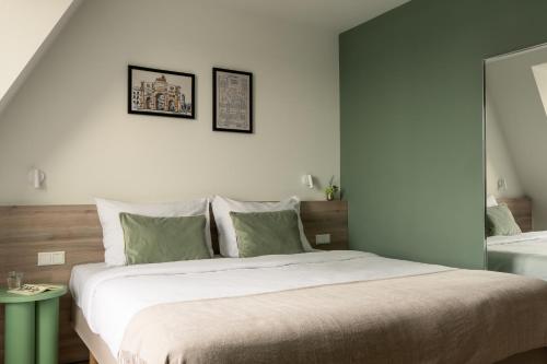 a bedroom with a large bed with two pictures on the wall at Bob W Munich City Centre in Munich