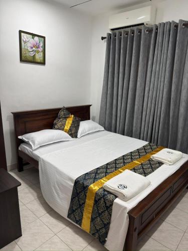 a bedroom with two beds and a window with curtains at Sleep Cheap Home in Negombo