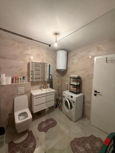 a bathroom with a toilet and a washing machine at Real Residence Bugojno in Bugojno