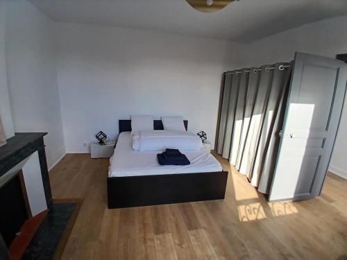 a bedroom with a bed with white sheets and pillows at 4-person apartment La Salamandre in Gondreville