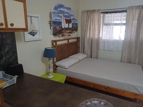 a small bedroom with a bed and a window at Gouritsmond Self Catering Units in Gouritzmond