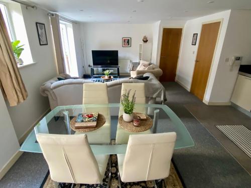 a living room with a glass table and chairs at Central Southsea Duplex Apartment 2BR Parking Dogs in Portsmouth