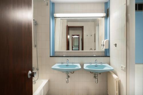 a bathroom with two sinks and a mirror at Hotel America Igualada in Igualada