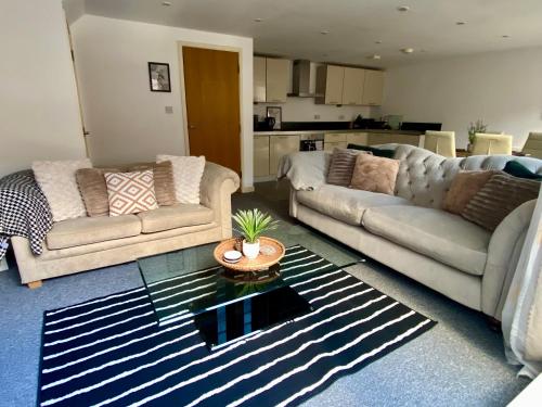a living room with two couches and a table at Central Southsea Duplex Apartment 2BR Parking Dogs in Portsmouth