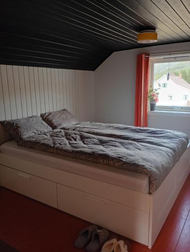 a bed in a room with a window at Hilltop wood house #1 all-inclusive in Kaupanger