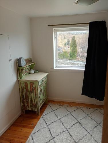 a room with a window and a dresser and a rug at Hilltop wood house #1 all-inclusive in Kaupanger