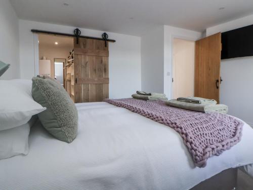a bedroom with a large white bed with towels on it at 10 South Street in Rossendale