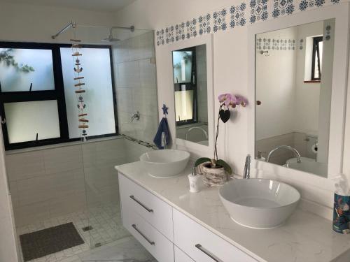 a white bathroom with two sinks and a shower at Shelley Cove in Stompneusbaai