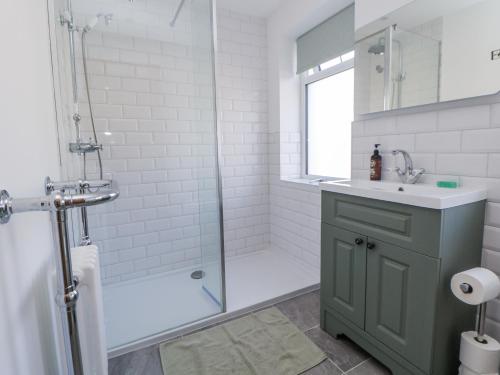 a bathroom with a shower and a sink and a glass shower backdoor at 10 South Street in Rossendale
