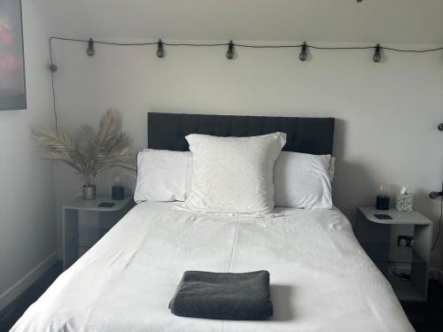 a bedroom with a white bed with a black blanket at 3 Linshader in Callernish