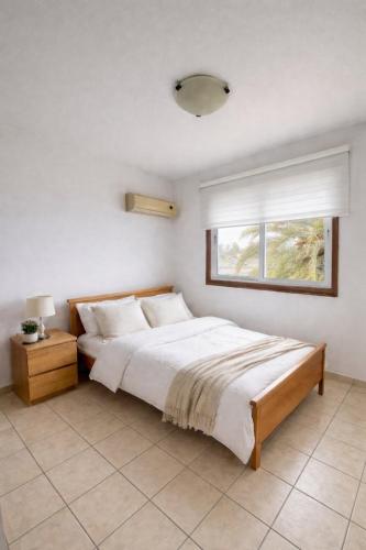 a bedroom with a large bed and a window at Seafront Escape Apartment in Oroklini