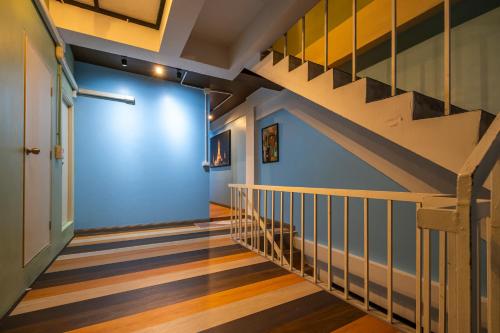 a hallway with a staircase with a blue wall at Queen On Street 2009 in Ban Lo Long