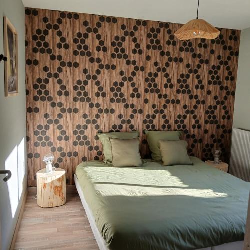 a bedroom with a bed and a wooden wall at La D'homette in Fresse-sur-Moselle