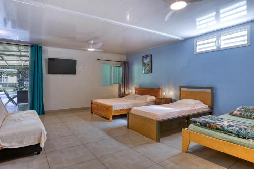 a room with two beds and a tv in it at L'Escale Royale in Salazie